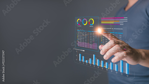 A person interacts with a glowing virtual dashboard displaying analytics and charts, emphasizing data analysis, business insights, and modern technology for decision making and performance tracking.