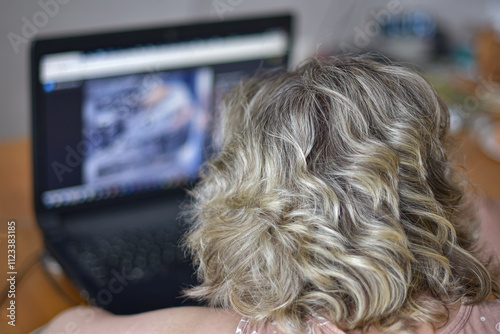 The girl looks at the laptop screen.