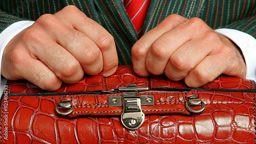 Close up of consultant hands holding red leather portfolio, showcasing professionalism and attention to detail. hands are positioned firmly, reflecting confidence