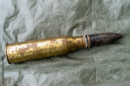 Old patinated artillery shell from World War II on a canvas photo