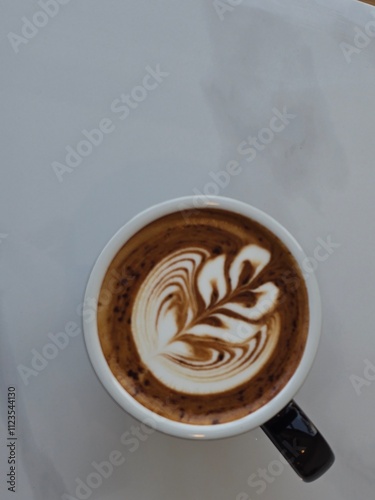 Artistic Latte in Black Mug on Wooden Table