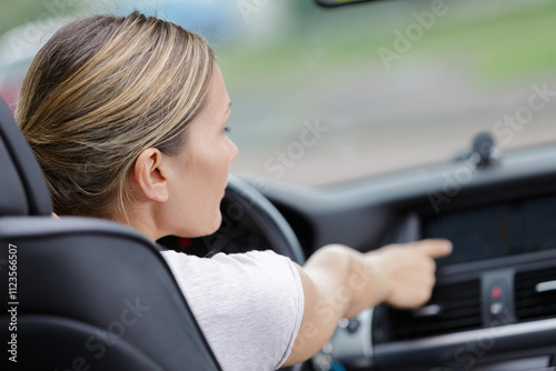 female driver adjusting car airconditioning photo