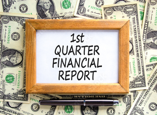 1st quarter financial report symbol. Concept words 1st quarter financial report on beautiful wooden frame. Beautiful dollar background. Business 1st quarter financial report concept. Copy space. photo