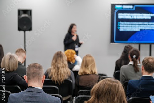 Wallpaper Mural Speaker holds presentation in front of diverse audience in modern conference setting. Attendees are engaged, listening to the presentation with interest. Torontodigital.ca