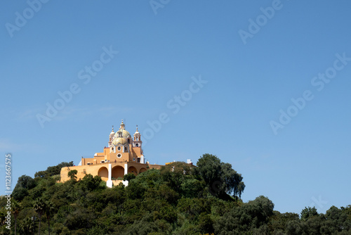 Stunning view of a historic church atop a lush hill on a clear day in Mexico