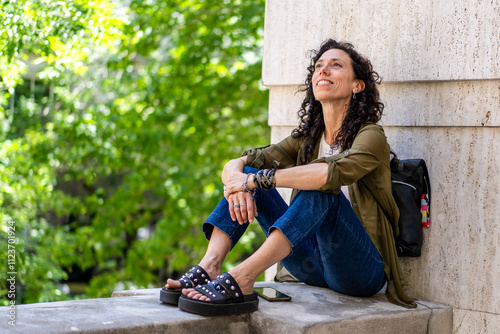 Relaxed woman sitting on a ledge enjoying nature photo