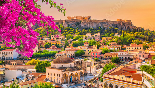 Fototapeta Naklejka Na Ścianę i Meble -  Skyline of Athens with Monastiraki square and Acropolis hill during sunset. Athens, Greece. Pink bougainvillea flower in the foreground