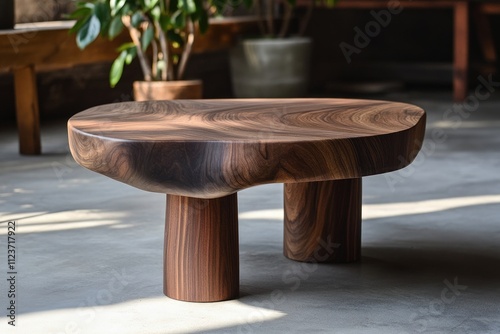 Rustic live-edge walnut coffee table with unique pedestal base on concrete floor.