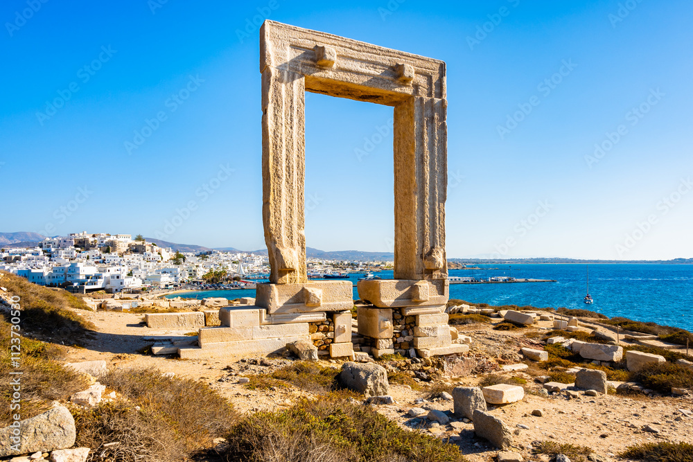 Portara monument also known as Temple of Apollo overlooking port and town on sea coast, Naxos island, Cyclades, Greece