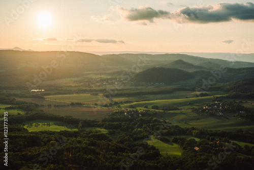 A stunning sunset over a valley with the sun shining through clouds