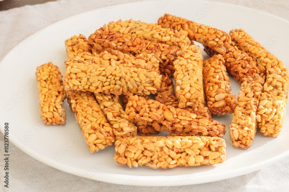 Gozinaki in a ceramic plate. Sweet granola in plate for holiday. Homemade seed sunflower candies. Gozinaki in a ceramic plate. Sweet granola in plate for holiday. Homemade seed sunflower candies.