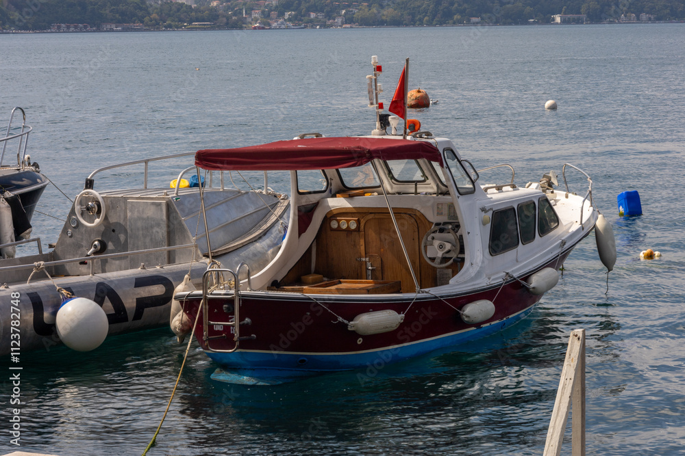 Obraz premium Classic Wooden Motorboat Moored in a Coastal Marina