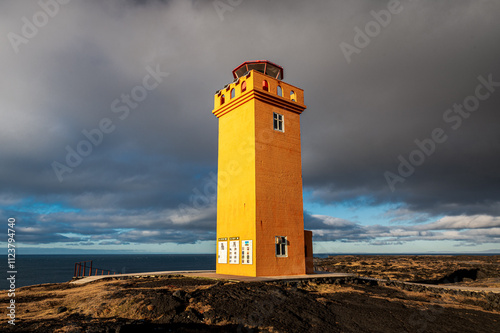 Phare orange de Svörtuloft, sur la péninsule de Snæfellsnes, sous un ciel menaçant