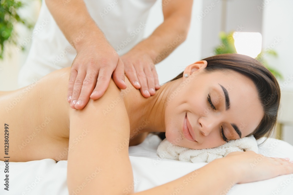 Obraz premium Spa therapy. Beautiful young woman lying on table during massage in salon, closeup