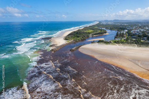 Aerial views of muddy waters from Cudgen Creek flowing in to the sea at Kingscliff headland seawall along the east coast of New South Wales, Australia photo