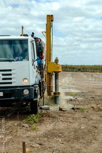 In an outdoor setting, this powerful auger drilling rig is captured in full operation, exemplifying technology and efficiency in soil drilling processes. The robust machine, with its yellow metal stru
