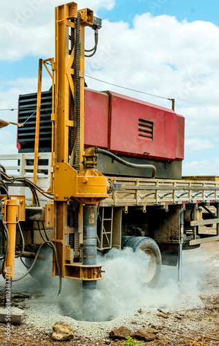 In an outdoor setting, this powerful auger drilling rig is captured in full operation, exemplifying technology and efficiency in soil drilling processes. The robust machine, with its yellow metal stru