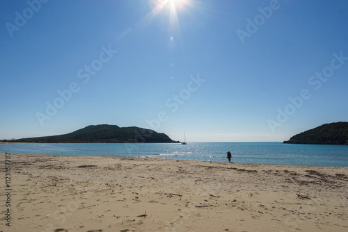 Tourist on empty Ammoudia beach on a sunny spring day, Ammoudia, Epirus, Greece photo