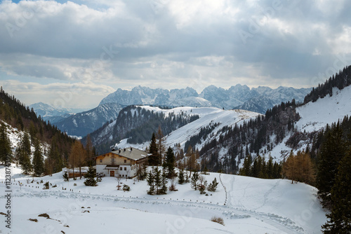 Winter landscape of Aschau im Chiemgau with snow-covered mountains and a cozy cabin photo