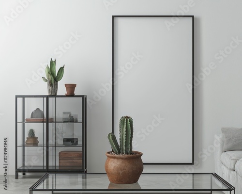 Clean living room with a blank frame, white walls, metal-framed cabinet, and a cactus centerpiece. photo