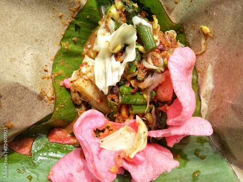 Lotek, traditional indonesian salad. Made from various kind of steamed vegetable mixed with spicy peanut sauce and crackers. photo