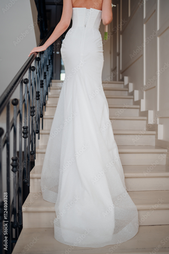 Fototapeta premium view from the back. a Beautiful and happy bride on a large beautiful staircase.