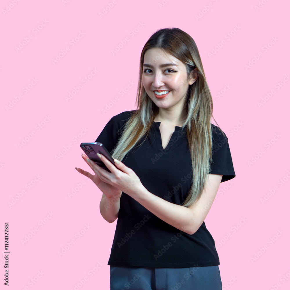 Young asian woman stand with a smile typing on smartphone. Portrait on pink background with studio light. Isolated. Young asian woman stand with a smile typing on smartphone. Portrait on pink background with studio light. Isolated.
