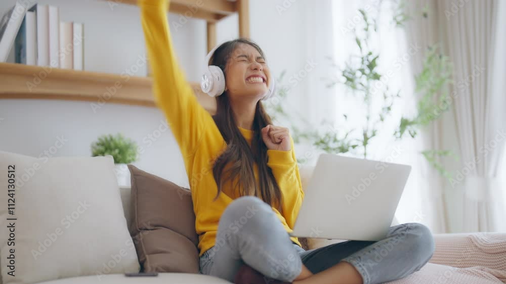 Funny euphoric young asian woman celebrating winning or getting ecommerce shopping offer on computer laptop. Excited happy girl winner looking at notebook celebrating success