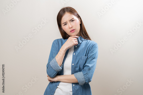 Portrait of face expression stress, asian young woman, confused girl standing pose looking camera in casual. unhappy female thinking creative, thinks about problem, isolated on background, copy space. photo