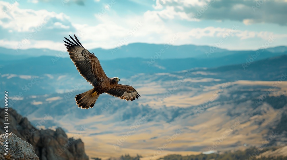 Obraz premium A bird of prey soaring above a vast landscape, capturing the wild beauty of untamed nature