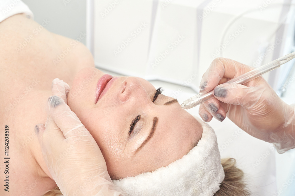 Mature caucasian female receiving forehead injection in a cosmetic clinic setting. Mature caucasian female receiving forehead injection in a cosmetic clinic setting.