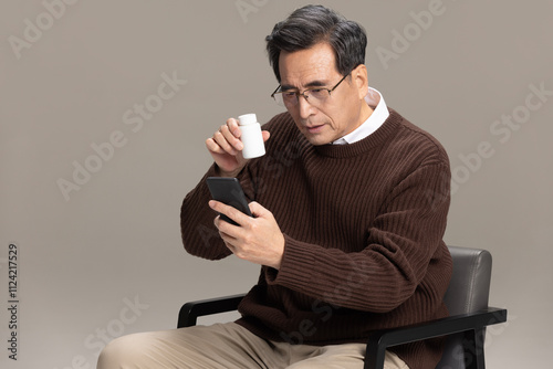 Senior Chinese man searching for instructions for pills photo