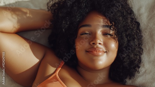 Body positive concept. Close up Beauty portrait of african american fat woman with clean healthy dark skin on neutral background. Smiling dreamy beautiful afro girl.