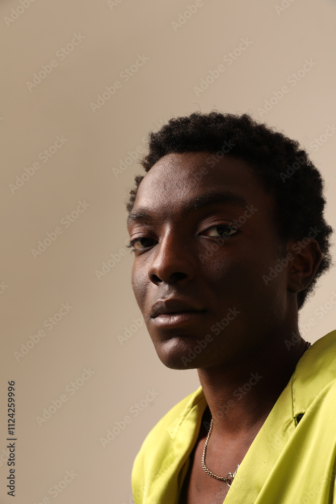 Portrait of young African American man looking at the camera and posing over light background. Vertical mock-up. Portrait of young African American man looking at the camera and posing over light background. Vertical mock-up.