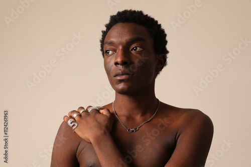 Portrait of young African American man posing over light background looking away. Vertical mock-up.