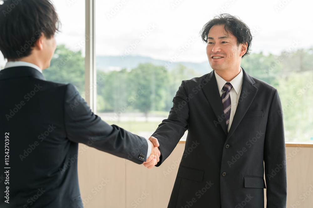 握手をする中年ビジネスマン（ロビー活動・ロビーイング・挨拶・契約・協定・合意）
