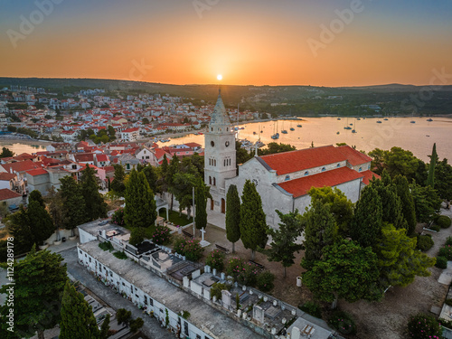 Obraz na płótnie Primosten, Croatia - Aerial view of St. George's Church on Primosten peninsula and old town on a sunny summer morning in Dalmatia, Croatia. Golden sky at sunrise by the Adriatic sea coast w salonie