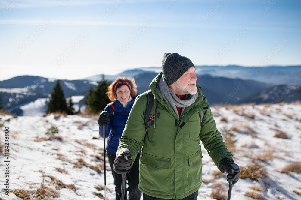 Winter hike for an elderly man and his wife in snowy mountains. Active seniors enjoying nature. Winter hike for an elderly man and his wife in snowy mountains. Active seniors enjoying nature.