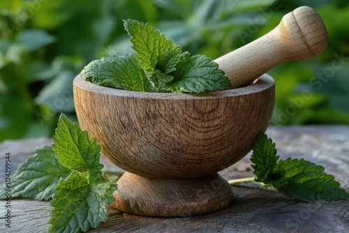 Wooden mortar used in herbal remedies Nettle based scalp treatments Nettle oil elixir for hair growth photo