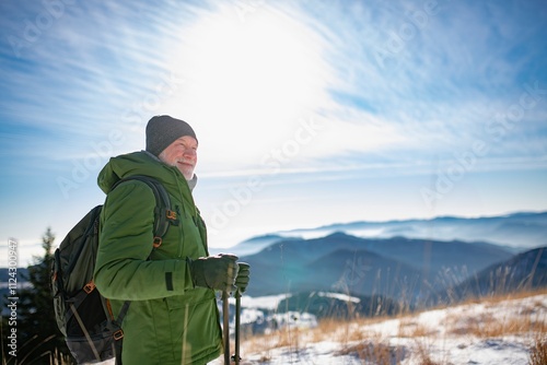 Winter hike for an elderly man in snowy mountains. Active senior enjoying nature.