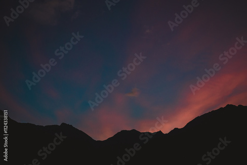 Mountains silhouetted against a orange and blue sunset photo