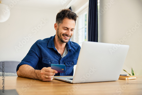 Foto Man paying online with credit card using laptop at home