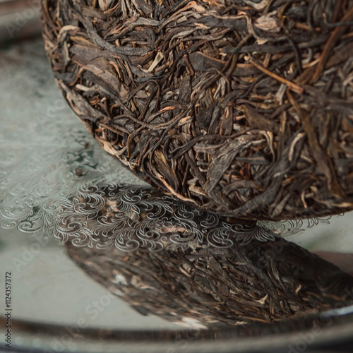 An Intriguing CloseUp of Compressed Tea Leaves Beautifully Reflecting on a Metal Surface photo