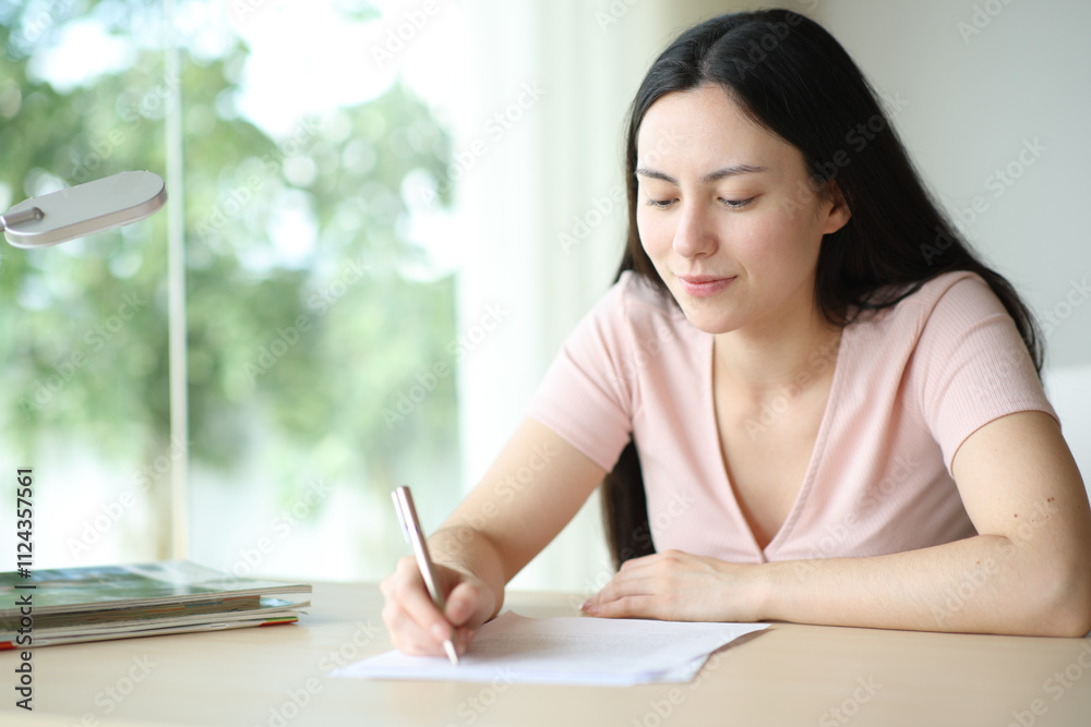 Asian woman signing contract or filling form at home Asian woman signing contract or filling form at home