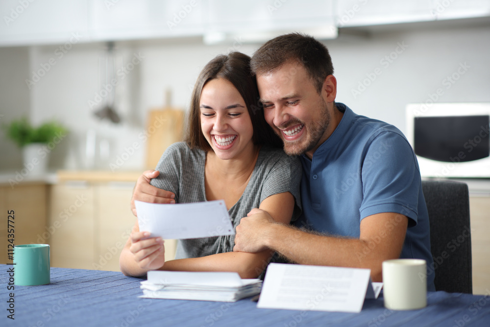 Happy couple checking bills at home Happy couple checking bills at home