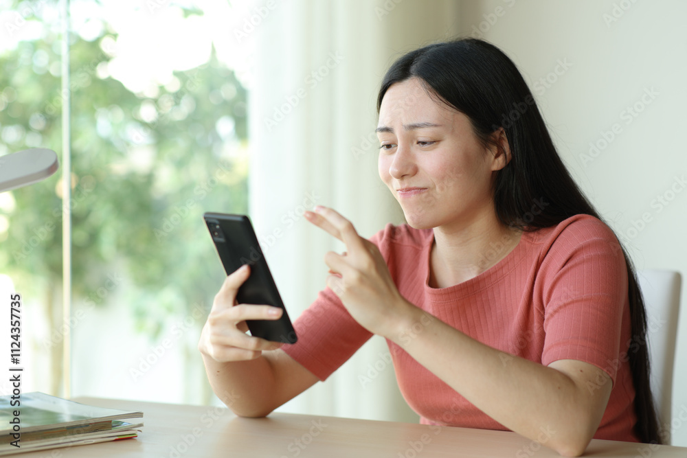 Doubtful asian woman crossing fingers checking phone Doubtful asian woman crossing fingers checking phone