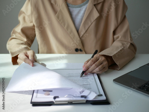 Young businesswoman holds a resume and evaluates it. Views the personal history of job applicants. Recruitment concept