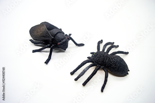 Realistic black plastic toy insects isolated on white background, featuring a spider and a beetle, perfect for educational or Halloween themed projects photo