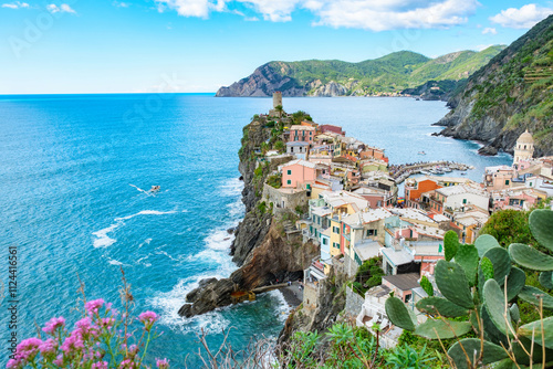 Tablou pe pânză Colorful houses perched along the rocky cliffs of Vernazza Italy while waves lap gently at the shore
