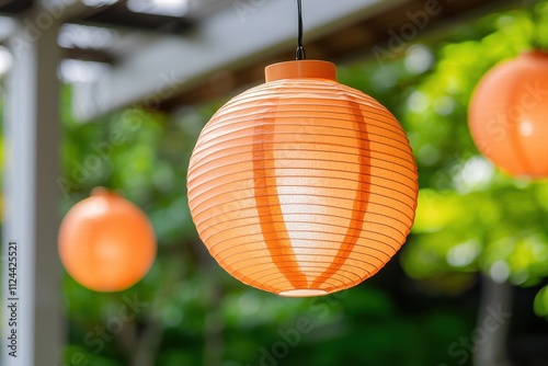 Lunar New Year theme Hanging orange lanterns create a warm, inviting atmosphere in a lush garden setting. photo